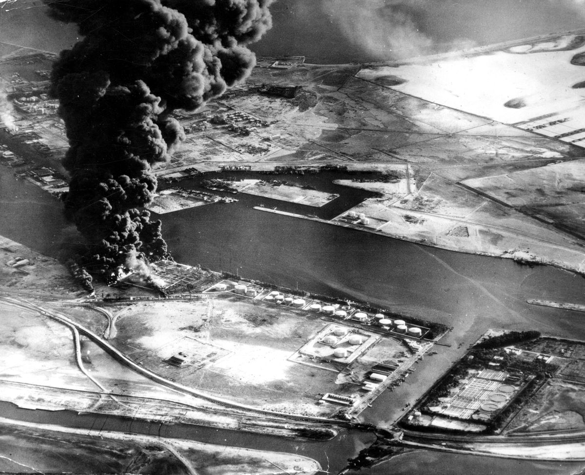 FILE - In this Nov. 11, 1956 file photo, fuel installations on the Suez Canal burn after an attack by aircraft of the Sea Venom Squadron from HMS Eagle as Britain, France and Israel intervened militarily and occupied the canal zone following Egypt nationalizing the canal. Since it opened in 1869, the canal has been a source of national pride and a focus of international conflict. Now, a skyscraper-sized container ship called the Ever Given got stuck sideways across the waterway since Tuesday, March 23, 2021 . The obstruction has halted canal traffic, valued at over $9 billion a day.  (STR)