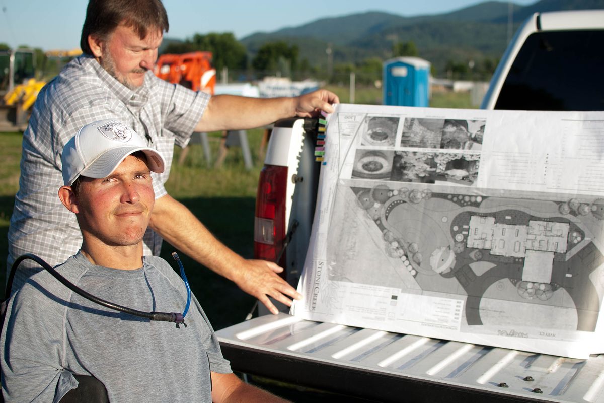 Casey McKern and Eric Weatherman, of Kettle Falls, display plans for a 4,000-square-foot single-level house designed to help people with spinal cord injuries. The project is supported by a partnership with Habitat for Humanity.
