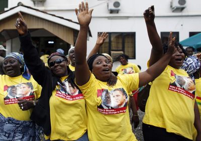 Women wearing T-shirts showing U.S. President Barack Obama and Ghanaian President John Atta Mills dance and sing as they leave for the airport to await Obama’s arrival in Accra, Ghana, on Friday.  (Associated Press / The Spokesman-Review)