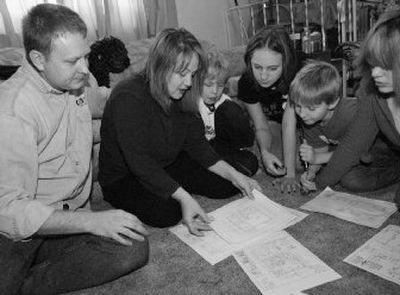 
The Warner family looks over plans for their new home in Anderson, Alaska, on Sunday. The family is expecting to get a free plot of land to build their dream home. 
 (Associated Press / The Spokesman-Review)