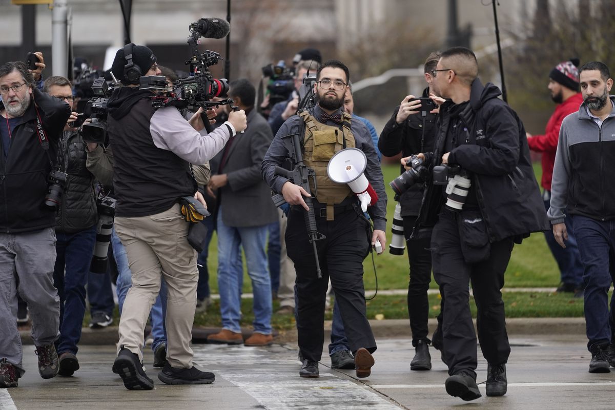 A protester carrying a rifle leaves the the Kenosha County Courthouse after speaking with Kenosha County Sheriffs Department officers, Wednesday, Nov. 17, 2021 in Kenosha, Wis., during the Kyle Rittenhouse murder trial. Rittenhouse is accused of killing two people and wounding a third during a protest over police brutality in Kenosha, last year.  (Paul Sancya)