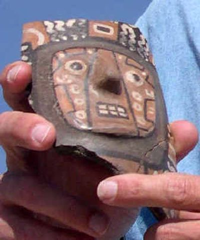 
A member of the scientific team excavating in Cerro Baul, a mountaintop city in the Andes, displays pieces of a ceramic drinking vessel found in the remains of a 1,000-year-old brewery discovered in July in Southern Peru.
 (Associated Press / The Spokesman-Review)