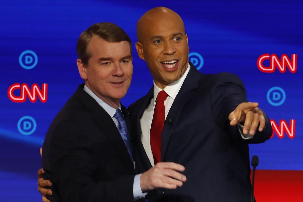 Sen. Michael Bennet, D-Colo., and Sen. Cory Booker, D-N.J. talk after the second of two Democratic presidential primary debates hosted by CNN Wednesday, July 31, 2019, in the Fox Theatre in Detroit. (Paul Sancya / Associated Press)