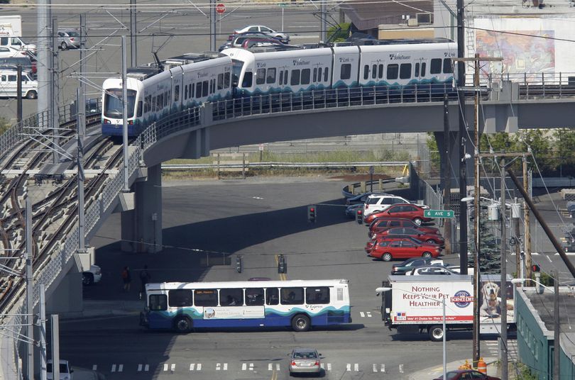 A Sound Transit light rail train passes over a Sound Transit bus as it makes a test run in Seattle, Wednesday, July 15, 2009. (Ted S. Warren / Associated Press)