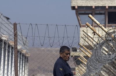 A prison guard walks in La Mesa State Penitentiary in Tijuana, Mexico, on Monday. The prison has been the scene of two riots this week.  (Associated Press / The Spokesman-Review)