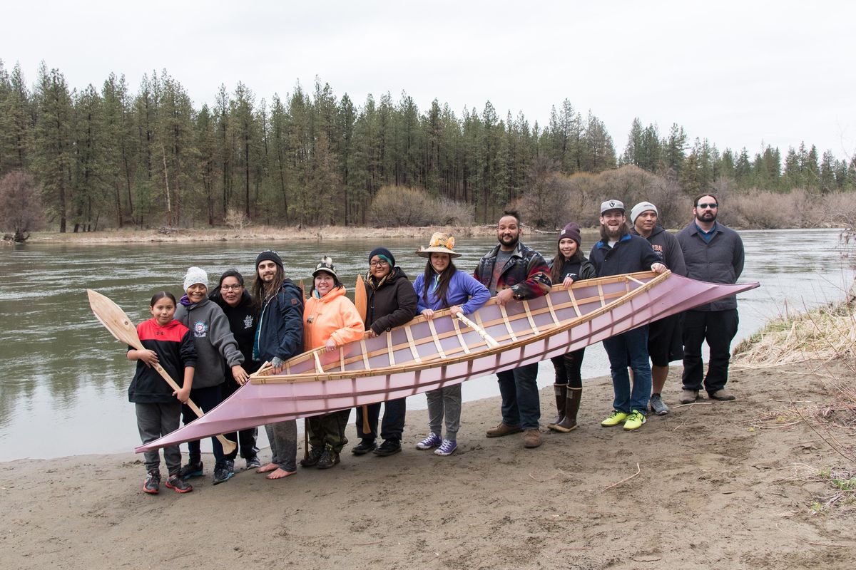 A group of students, parents and staff from the Spokane Salish school poses with the canoe they built over spring break. The canoe was built using traditional Native American practices. The project was funded by the Burke Museum. (Eli Francovich / The Spokesman-Review)