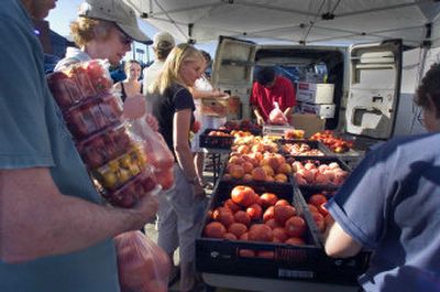 
Shoppers line up to buy fresh  tomatoes and other produce at the Spokane Farmers' Market on Second Avenue just off Division. 
 (Christopher Anderson/ / The Spokesman-Review)