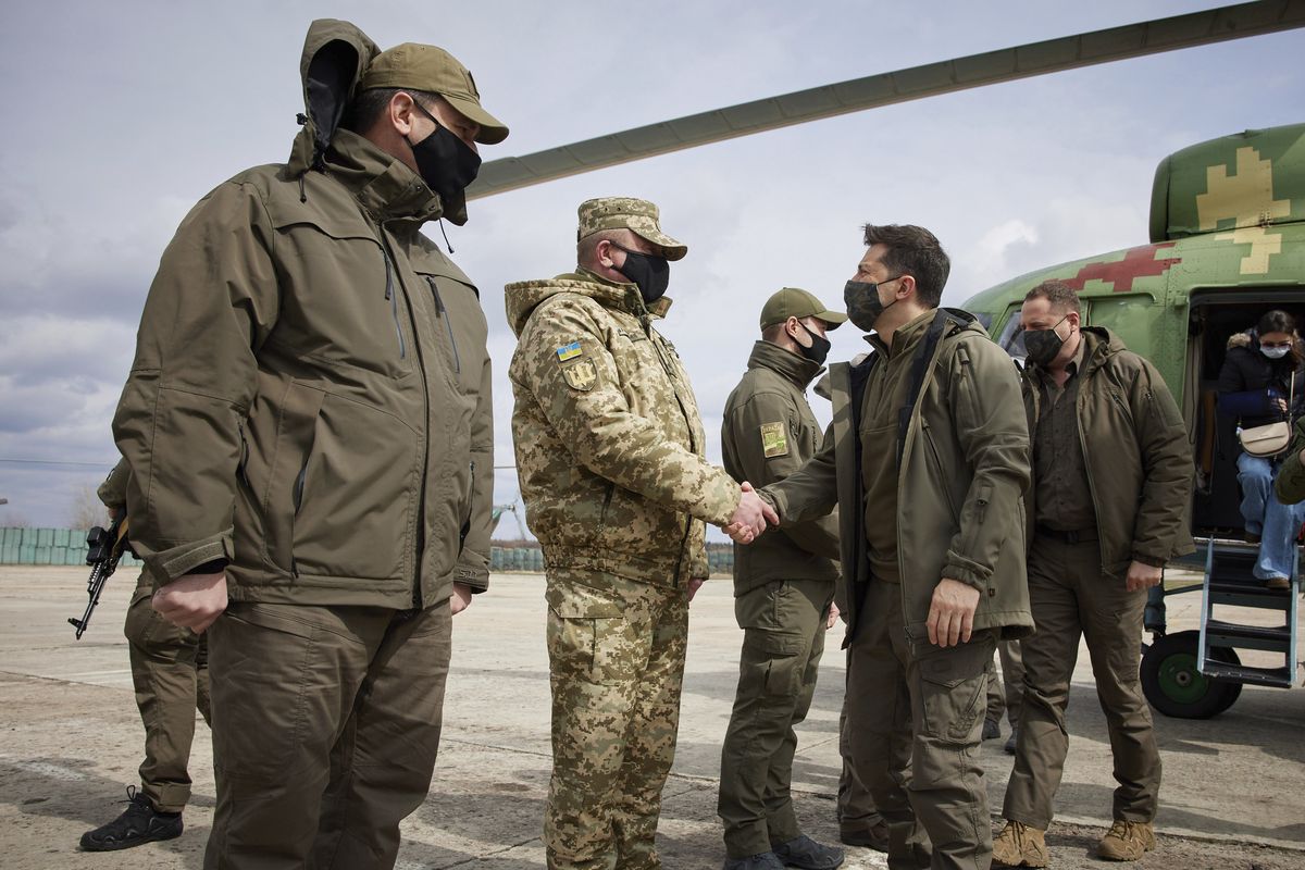 Ukrainian President Volodymyr Zelenskiy shakes hands a soldier as he visits the war-hit Donbas region, eastern Ukraine, Thursday, April 8, 2021. Ukraine is at the center of a major geopolitical battle in the eastern part of the country with Moscow backed separatists.  (HOGP)