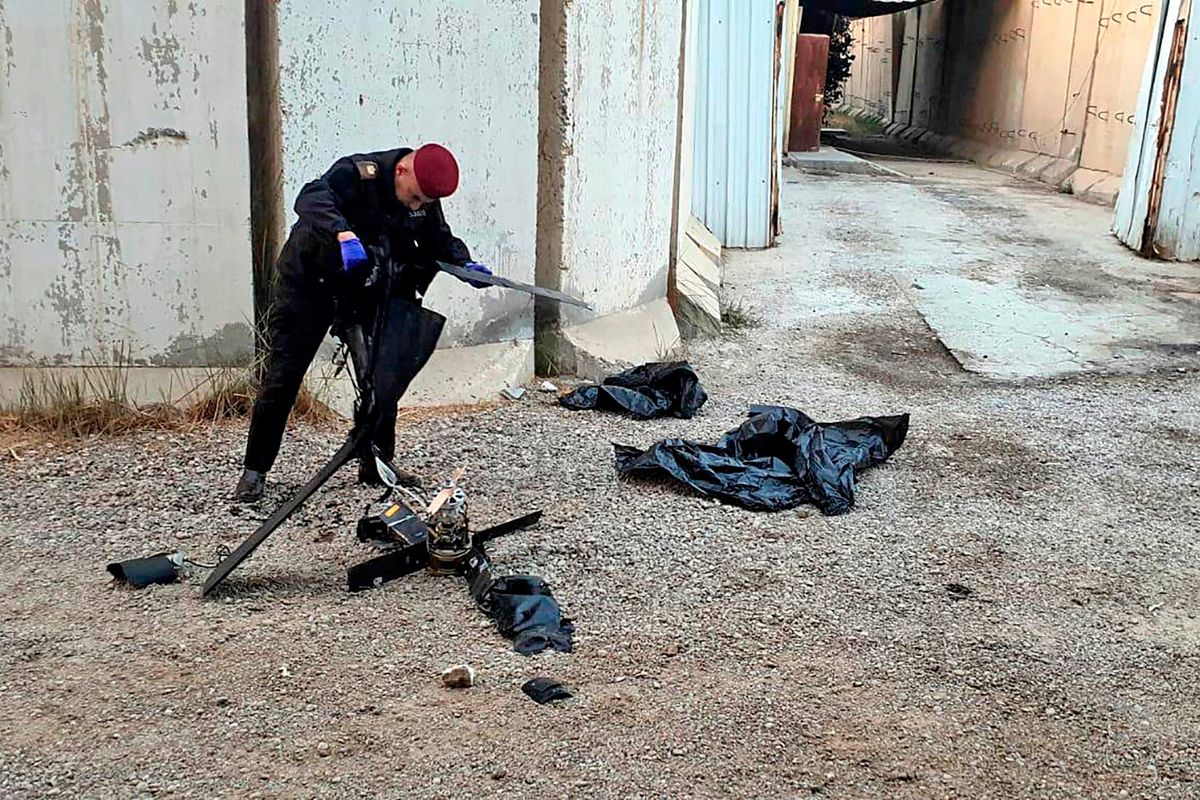 A security official inspects the wreckage of a drone at Baghdad airport in Iraq on Monday.  (HO)