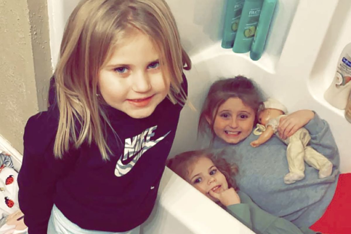 In this Dec. 10, 2021, photo provided by Sandra Hooker, from left, Avalinn Rackley, 7, Alanna Rackley, 3, and Annistyn Rackley, 9, pose for a picture in a bathroom in their home near Caruthersville, Missouri. Annistyn, a third-grader who loved swimming, dancing and cheerleading, was among dozens of people who died because of the severe storm on Friday, Dec. 10. A tornado hit her home and splintered it less than a week after the family had moved in, and, according to the relative who received the photo of the girl in the bathtub, it carried family members dozens of yards before dropping them in a muddy field.  (Meghan Rackley)