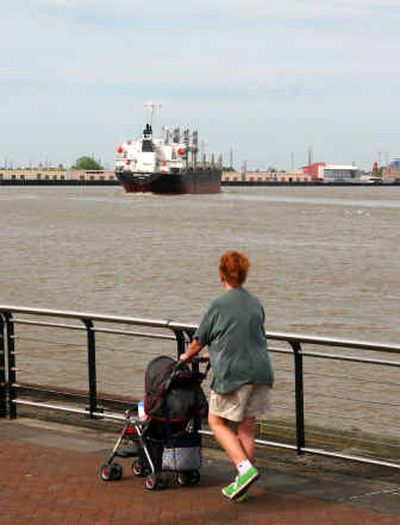 
A mother pushes her child along the banks of the Mississippi River at the Port of New Orleans as an oceangoing vessel heads downriver. 
 (Associated Press / The Spokesman-Review)