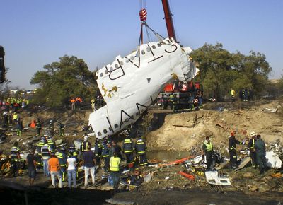 A part of the fuselage of the Spanair jet that crashed on takeoff Wednesday at Madrid’s Barajas airport is lifted by a crane.  (Associated Press / The Spokesman-Review)