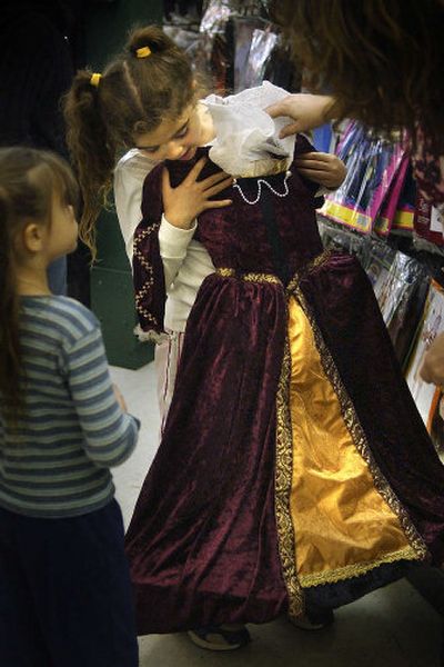 
Hayley Louik, 7, considers a princess dress for her Halloween costume with the help of her sister, Abigail Louik, 5, and mom Raquel Louik at the Display House in Spokane Valley.
 (The Spokesman-Review)