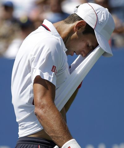 Novak Djokovic wipes away sweat during his four-set loss to Kei Nishikori in New York on Saturday. (Associated Press)