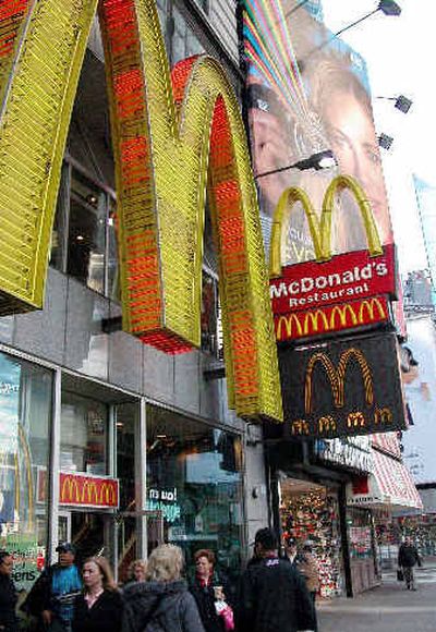 
Pedestrians pass beneath the large neon 'M' that marks the McDonald's in New York's Times Square. McDonald's reported a 42 percent increase in third-quarter profits on Tuesday.
 (Associated Press / The Spokesman-Review)