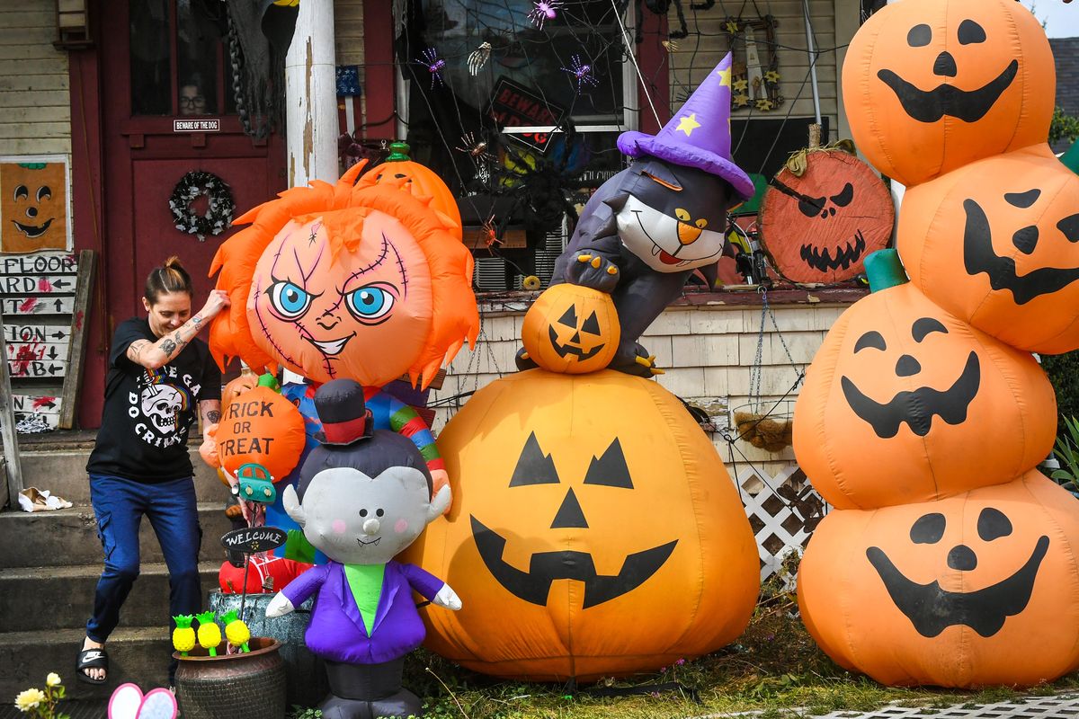 Tonya Hinshaw, 45, wiggles into position her latest addition to her Halloween decoration collection, a Chucky” inflatable, Wednesday, in her front yard at the corner of Nevada Street and Dalton Avenue in Spokane.  (DAN PELLE/THE SPOKESMAN-REVIEW)