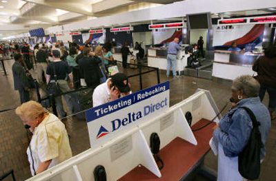 
Delta Air Lines passengers use a phone ticketing kiosk, while others behind them wait in line to check in, for the start of a busy Easter holiday weekend of travel at Atlanta's Hartsfield-Jackson International Airport on Friday. 
 (Associated Press / The Spokesman-Review)
