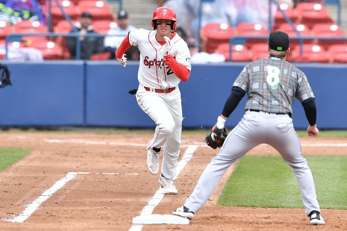 Spokane’s Robby Martin Jr. sprints to first base Tuesday while Eugene first baseman Justin Bench awaits the throw at Avista Stadium.  (Tyler Tjomsland/The Spokesman-Review)