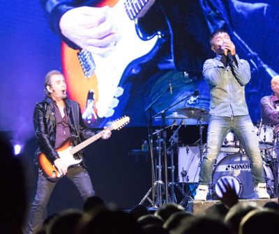 Journey lead singer Arnel Pineda, right, sings alongside keyboardist Jonathan Cain, who steps out to play guitar on a song in 2017 at the Spokane Arena. The band will bring its 50th anniversary tour to the Arena on Friday.  (JESSE TINSLEY)