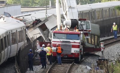 A demolished train car is lowered as officials continue to work around the scene of a rush-hour collision between two Metro transit trains in northeast Washington, D.C.  (Associated Press / The Spokesman-Review)