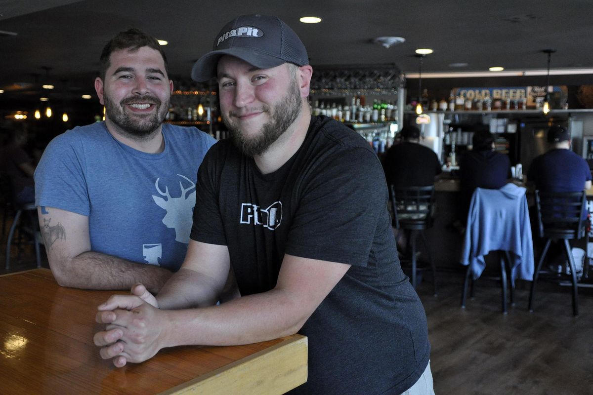 Logan Tavern owners J.D. Winn (right) and Nehemiah Zilar pose in the dining room of their establishment, located near the Gonzaga University campus. (Adriana Janovich / The Spokesman-Review)