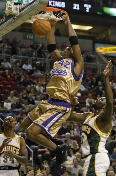 
Sacramento's Bonzi Wells dunks between Seattle's Reggie Evans, left, and Ray Allen. 
 (Associated Press / The Spokesman-Review)