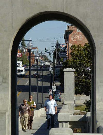 
Pedestrians head south across the renovated Monroe Street Bridge earlier this summer. Spokane's downtown business district is burgeoning. 
 (The Spokesman-Review)
