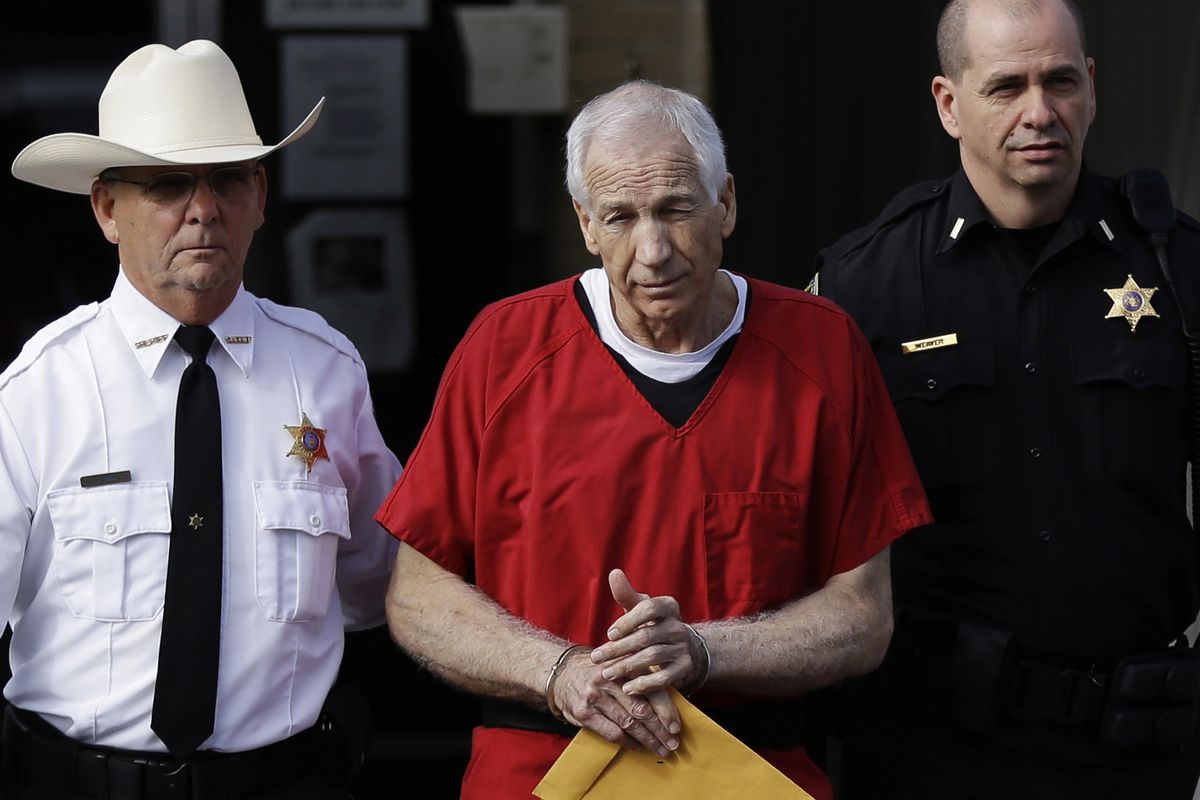 Former Penn State University assistant football coach Jerry Sandusky, center, is taken from the Centre County Courthouse by Centre County Sheriff Denny Nau, left, and a deputy, after being sentenced in Bellefonte, Pa., Tuesday, Oct. 9, 2012. Sandusky was sentenced to at least 30 years in prison, effectively a life sentence, in the child sexual abuse scandal that brought shame to Penn State and led to coach Joe Paterno's downfall. (Matt Rourke / Associated Press)