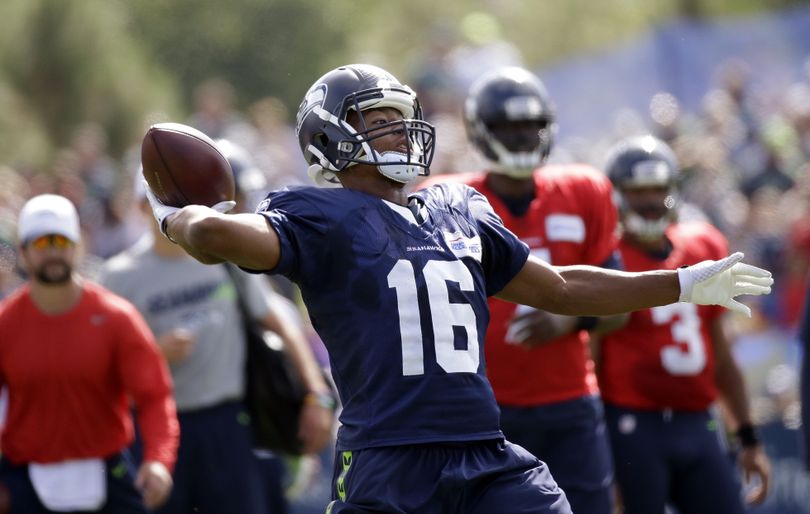 Seahawks receiver Tyler Lockett drops back to pass after being flipped the ball behind the line of scrimmage at training camp. (Associated Press)
