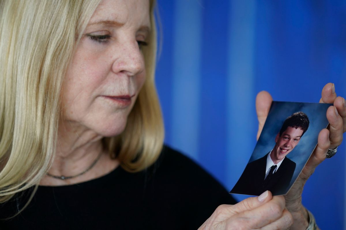 Dede Yoder poses for a picture with a photo of her son, Chris Yoder, after making a statement during a opiod addiction hearing in New York, Thursday, March 10, 2022.   (Associated Press)