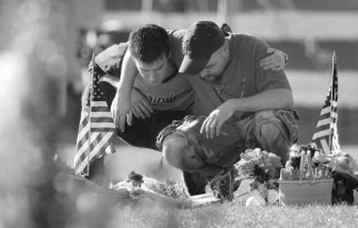 
Joshua Stevens, right, of Blacksburg, Va., embraces former Virginia Tech student Russell Miller, of Richmond, Va., as they visit the makeshift memorial on campus Saturday. 
 (Associated Press / The Spokesman-Review)