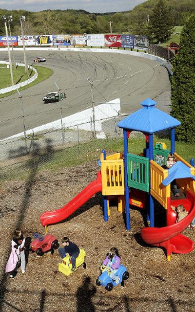 
Children play in the new playground as race cars do practice laps around turn one at Jennerstown Speedway in Jennerstown, Pa. The owners of the track have tried to make the destination more appealing as family entertainment.
 (Associated Press / The Spokesman-Review)