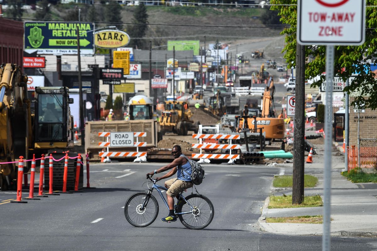 A cyclist crosses Monroe Street at Mansfield Avenue as the road is under construction, Thursday, May 3, 2018, in Spokane, Wash. (Dan Pelle / The Spokesman-Review)