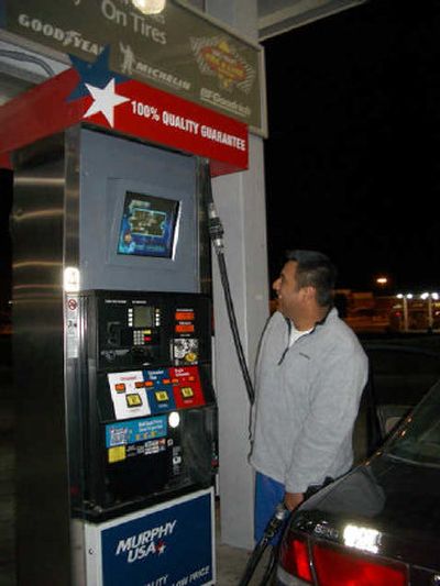 
A customer watches a television installed at the pump.
 (Associated Press / The Spokesman-Review)