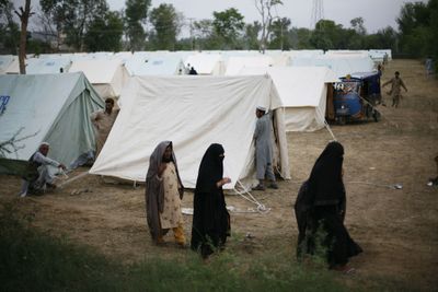 Pakistani women walk past tents at a refugee camp in Mardan,  Pakistan, on Thursday. Thousands of residents are fleeing fighting between the army and Taliban militants in the Swat Valley.  (Associated Press / The Spokesman-Review)