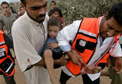
Palestinians carry a young boy wounded when Israeli artillery destroyed a building Thursday in the town of Rafah, southern Gaza Strip. The violence ended weeks of relative calm.
 (Associated Press / The Spokesman-Review)