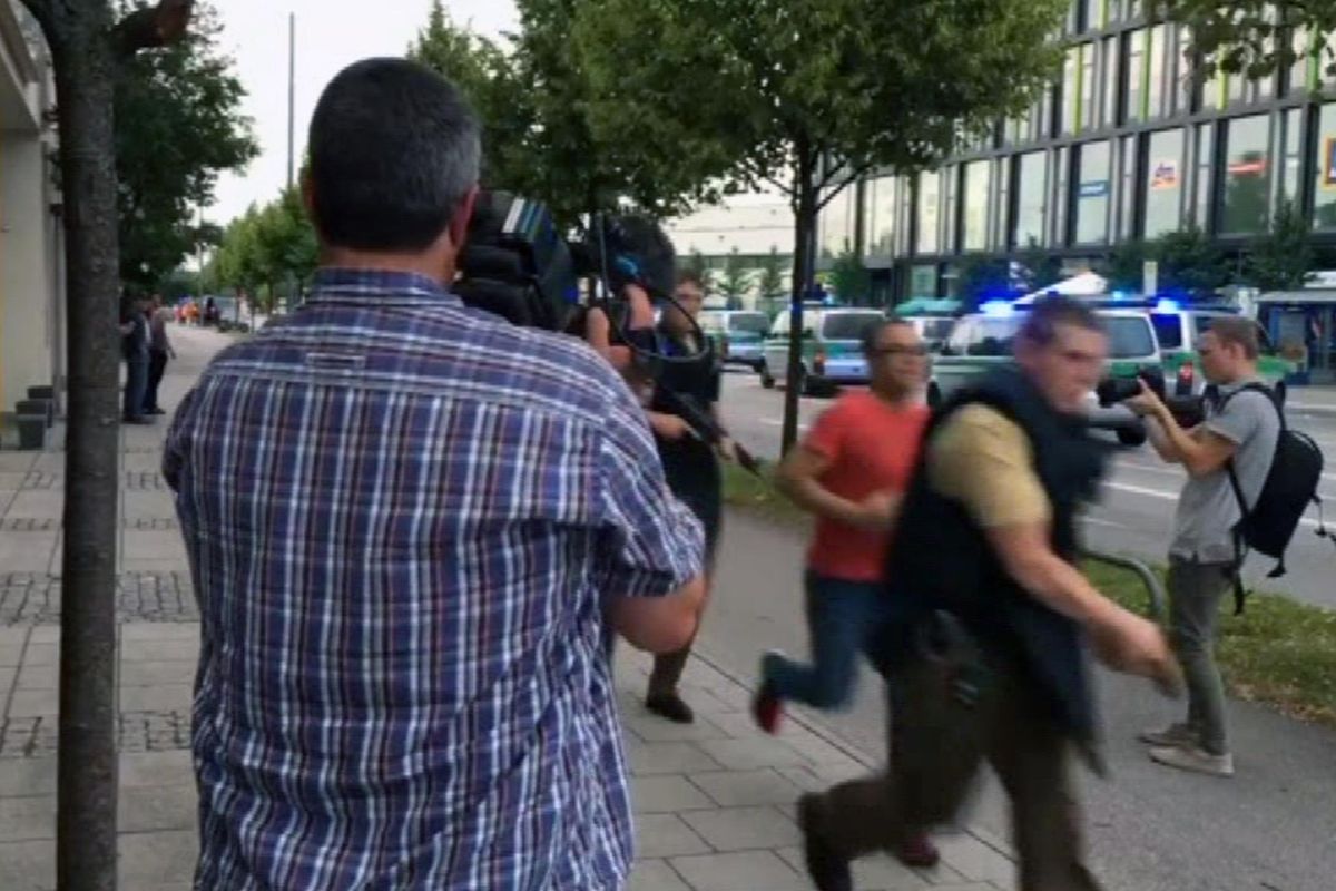Armed police move past onlooking media responding to a shooting at a shopping center in Munich, Germany, Friday July 22, 2016. Munich police confirm shots have been fired at Olympia Einkaufszentrum shopping center but say they don’t have any details about casualties. Police are responding in large numbers. (APTV / Associated Press)