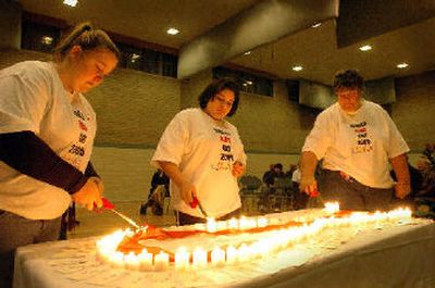 
Tiffany Hopper, Dana Garroway and Lisejean Freed on Thursday light candles representing North Idahoans living with HIV at a World AIDS Day ceremony at Coeur d'Alene's Harding Center. 
 (Jesse Tinsley/The Spokesman-Revi / The Spokesman-Review)