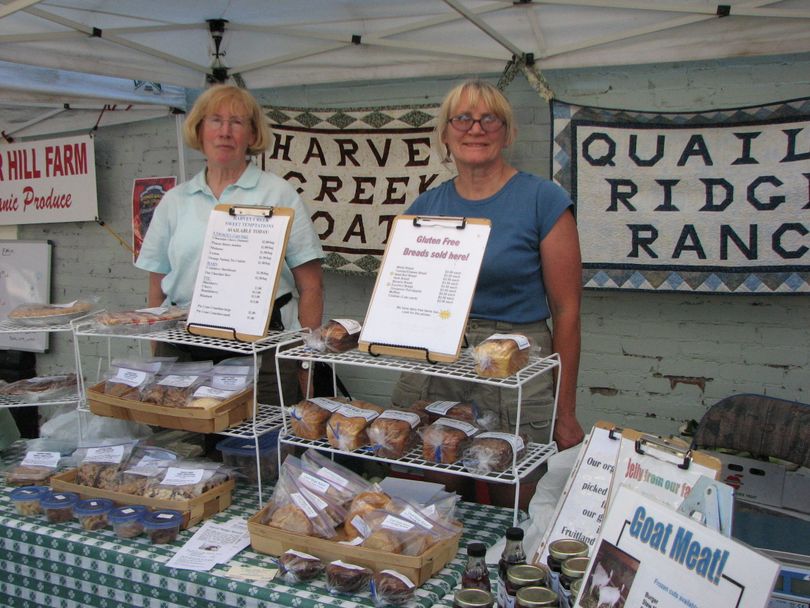 Friends Hannah Kirk of Harvey Creek Goats (left) and Jane Keolker of Quail Ridge Ranch, at their booth at the Perry Street Farmers' Market. They sell Boer goat meat and gluten free bread, plus jams from Keolker's ranch and veggies from Kirk's place. (Pia Hallenberg)