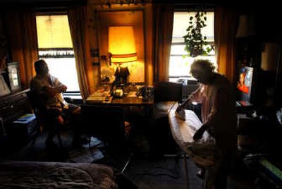 
Faye Melbourne, right, irons clothes while roommate Joe Carraway watches game shows Wednesday at The Briggs Apartments in downtown Spokane. Melbourne has lived in the same apartment for 23 years and may have to move. 
 (Brian Plonka / The Spokesman-Review)