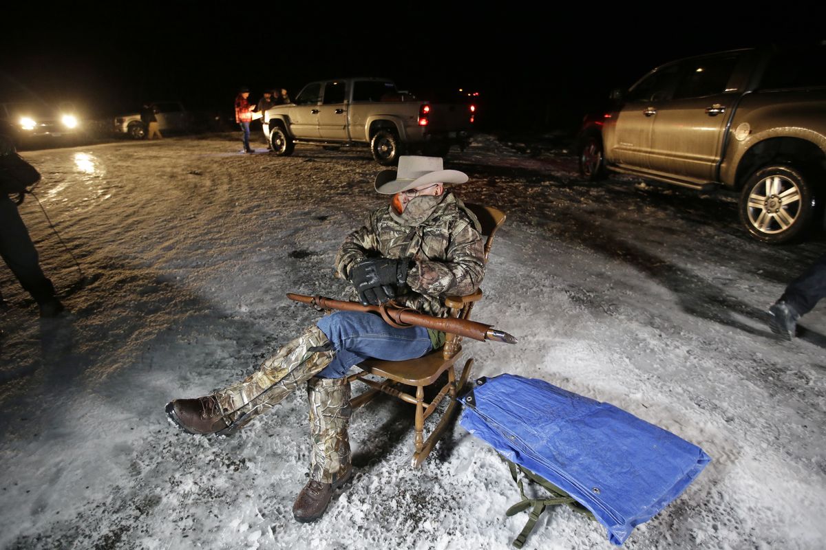 In this Jan. 5, 2016 photo, Arizona rancher LaVoy Finicum holds a gun as he guards the Malheur National Wildlife Refuge near Burns, Ore. Finicum, one of the leaders of the armed takeover of the refuge, was later shot by state police officers after he fled an attempted police stop. Experts say right-wing extremism like the Malheur takeover had previously mostly played out in isolated pockets or smaller cities in America before the deadly assault by rioters on the U.S. Capitol earlier this month.  (Rick Bowmer)