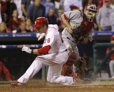 Philadelphia Phillies' Chase Utley scores as Cincinnati Reds catcher Ramon Hernandez bobbles the throw. (Associated Press)