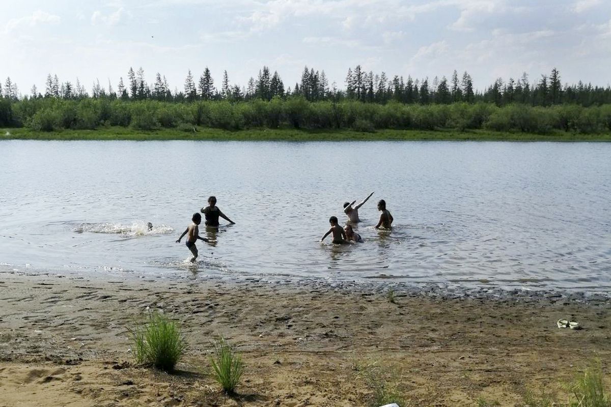 In this handout photo taken Sunday, June 21, 2020 and provided by Olga Burtseva, children play in the Krugloe lake outside Verkhoyansk, the Sakha Republic, about 4660 kilometers (2900 miles) northeast of Moscow, Russia. A record-breaking temperature of 38 degrees Celsius (100.4 degrees Fahrenheit) was registered in the Arctic town of Verkhoyansk on Saturday, June 20 in a prolonged heatwave that has alarmed scientists around the world.  (Olga Burtseva)