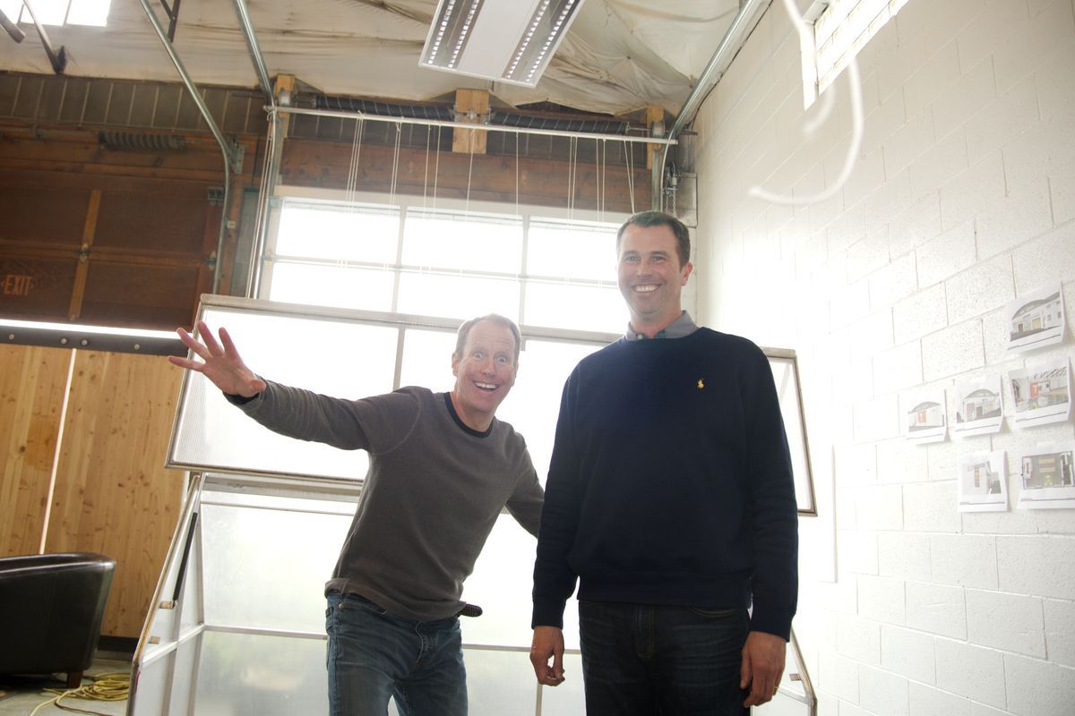 Tom Simpson, left, and Andy Barrett stand inside Toolbox, an incubator for inventors, manufacturers and tinkerers in a former industrial space on the McKinstry campus last week. Projects include window blinds, greenhouses and canopies. The space will house several groups and manufacturers at once, spinning them off as they are able. (Jesse Tinsley)