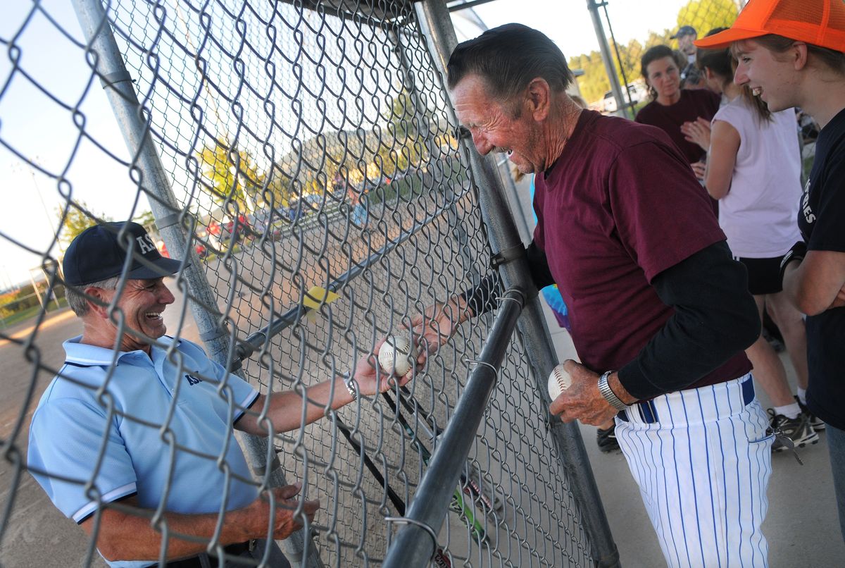 Don Shove gives a game ball to umpire John Bell before the start of their game at Ramsey Field in Coeur d’ Alene Monday. At 72, Shove has been playing with his family for almost two decades.  (Photos by RAJAH BOSE / The Spokesman-Review)
