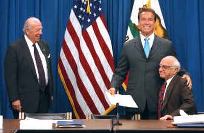 
California Gov. Arnold Schwarzenegger, center, and Milton Friedman of the Hoover Institution, right, joke about making the movie 