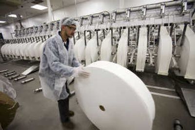 
Jimmy Santiago rolls a spool of cloth destined to be made into baby wipes as he maintains a sorting and cutting machine at the Nice-Pak factory Jan. 18 in Orangeburg, N.Y. Manufacturers faced weakening orders and higher prices for raw materials in March. Associated Press
 (File Associated Press / The Spokesman-Review)