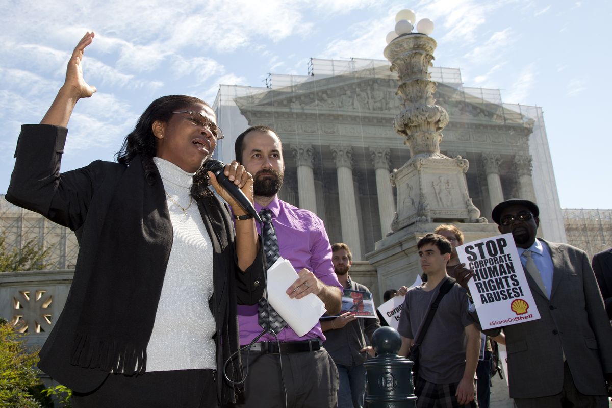 Nigerian widow Esther Kiobel, a plaintiff in Kiobel v. Royal Dutch Petroleum, cries as she speaks outside the Supreme Court in Washington, Monday, Oct. 1, 2012. Standing with her second from left is Brad Weikel with EarthRights International. (Carolyn Kaster / Associated Press)
