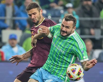 Portland Timbers defender Dario Župaric and Seattle Sounders forward Jordan Morris wrestle for position Saturday evening at Lumen Field in Seattle on October 19, 2024  (Kevin Clark/Seattle Times)