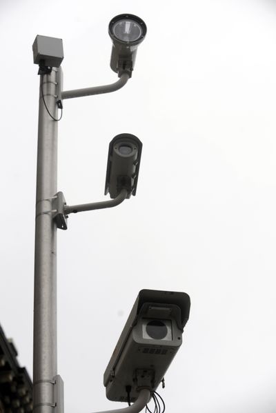 The red light camera system in Spokane uses two cameras and a flash on a pole, plus a control box, which combine to monitor the roadway for red light runners. (File)